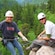 A woman in a helmet holds on to her hiking rope as she begins her descent down the side of a cliff